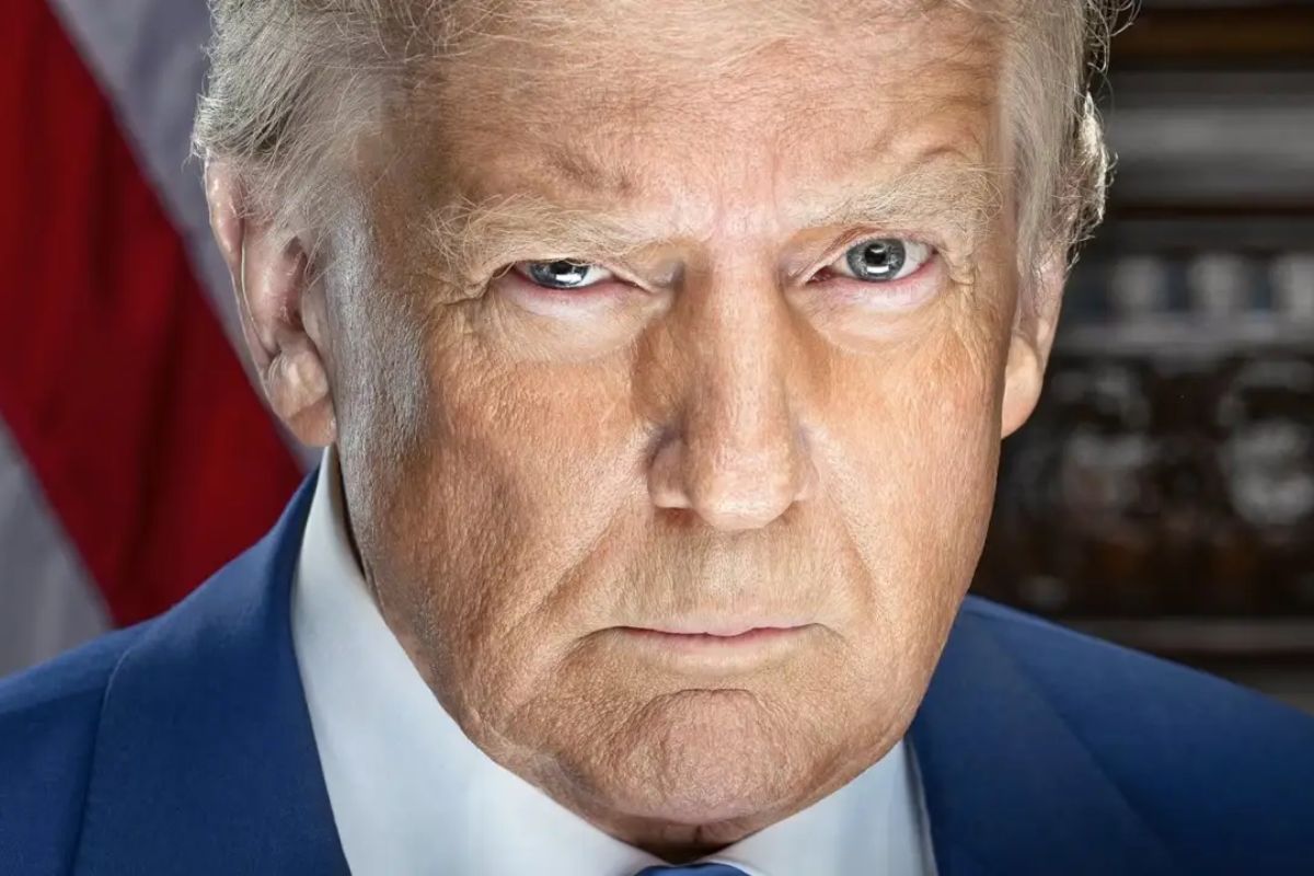 Imagem de Donald Trump, presidente dos Estados Unidos, com expressão séria, usando terno azul e gravata, em ambiente formal.