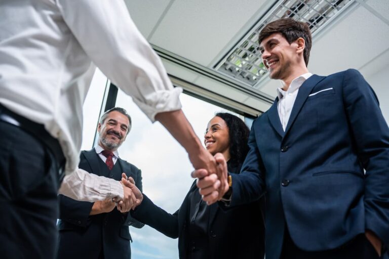 Empresários apertando as mãos em reunião de negócios, simbolizando parceria e sucesso em microfranquias.