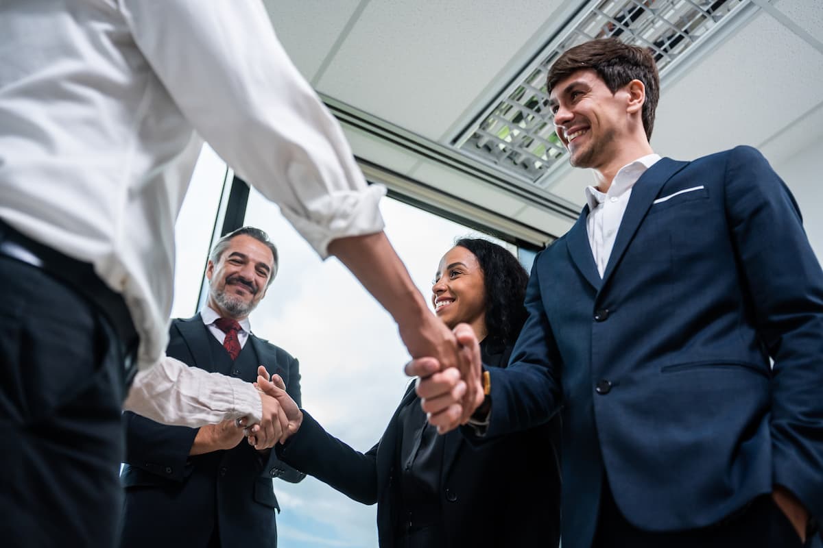 Empresários apertando as mãos em reunião de negócios, simbolizando parceria e sucesso em microfranquias.