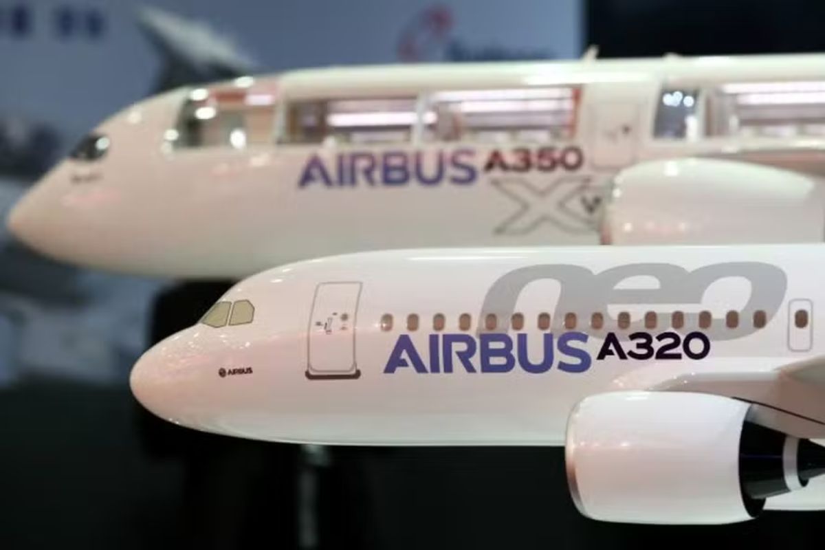 Close-up de dois modelos de aeronaves Airbus em miniatura. O modelo em primeiro plano, mais nítido, é o Airbus A320neo, com a fuselagem branca exibindo a inscrição "AIRBUS A320neo" em roxo e cinza.