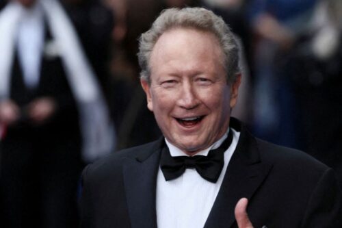 Close-up do empresário australiano Andrew Forrest, com cabelos grisalhos e um sorriso largo, vestindo um smoking preto com camisa social branca e uma gravata borboleta preta, em um evento formal.