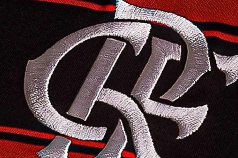 Close-up do monograma do clube, que exibe as letras "CRF" (sigla para Clube de Regatas do Flamengo), bordadas em um tecido com as tradicionais listras vermelhas e pretas do time.