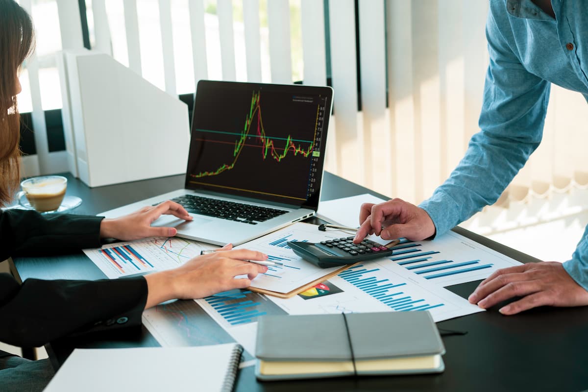 Profissionais analisando gráficos e relatórios financeiros sobre empresas que mais pagaram dividendos em 2025