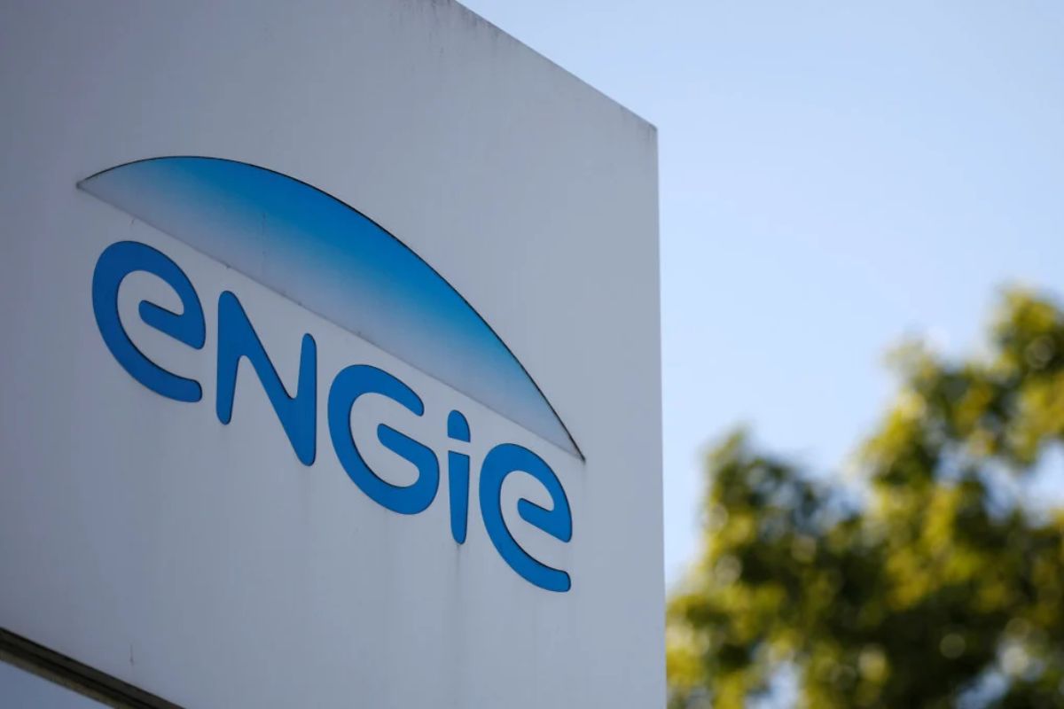 Logomarca da empresa de energia Engie (EGIE3) em uma placa branca contra um céu claro, focada na palavra "engie" em azul.