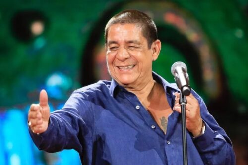 Zeca Pagodinho no palco, com expressão alegre e descontraída.
