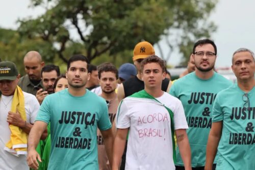 Fotografia de um grupo de pessoas caminhando em uma manifestação de rua.