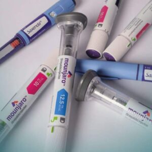 Diversas canetas injetáveis de medicamentos para perda de peso espalhadas sobre uma superfície clara.