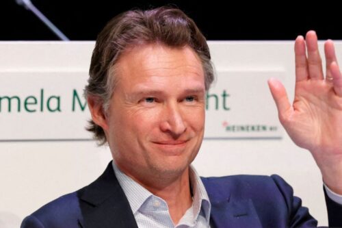 Dolf van den Brink, CEO da Heineken, sorrindo e acenando durante um evento corporativo.