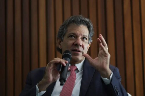 Fotografia em plano médio do político Fernando Haddad falando ao microfone.