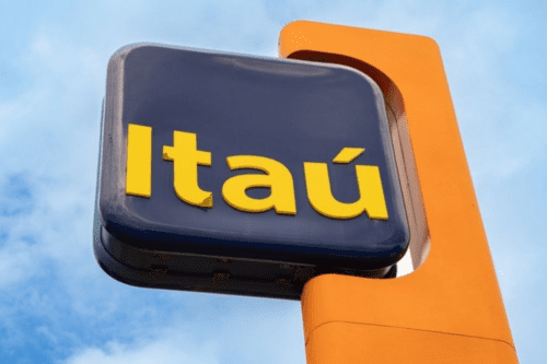 Logomarca do banco Itaú em destaque, localizado em um poste com fundo de céu azul. Ideal para quem busca informações sobre o banco Itaú.