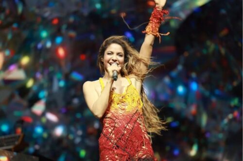 Fotografia da cantora Shakira sorrindo durante uma performance no palco.
