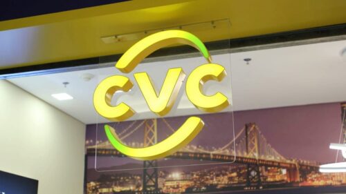 Logo da CVC em unidade física da empresa; imagem ilustrativa relacionada à CVC e às ações CVCB3 no mercado financeiro.