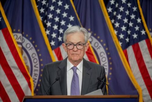 Jerome Powell, presidente do Fed, fala em coletiva do Federal Reserve, diante de bandeiras dos Estados Unidos.