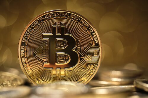 Moeda de Bitcoin em destaque; Bitcoin pode bater novos recordes com valorização do mercado cripto e expectativa de alta.