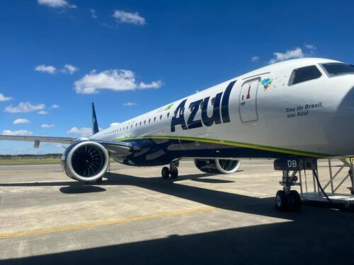Avião da Azul (AZUL4) em pista de aeroporto, com logotipo da companhia aérea e céu azul ao fundo.