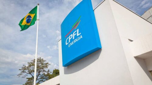 Prédio da CPFL Paulista com logotipo da empresa em destaque e bandeira do Brasil hasteada ao lado.