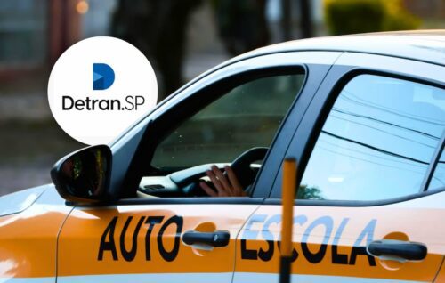 Carro de autoescola em via urbana, com logotipo do Detran.SP e motorista ao volante durante aula prática.