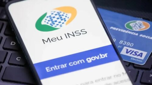 Aplicativo Meu INSS aberto no celular ao lado de cartão, ilustrando consulta da tabela do INSS 2026 e serviços previdenciários.