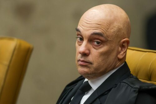 Retrato em close do ministro Alexandre de Moraes. Ele olha para o lado com uma expressão séria e concentrada.