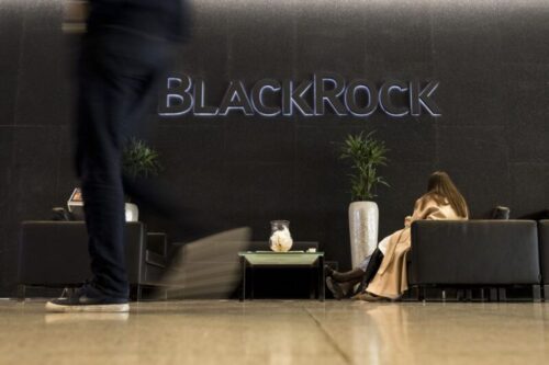 Recepção moderna com uma parede escura onde se destaca o nome 'BlackRock' em letras metálicas retroiluminadas.