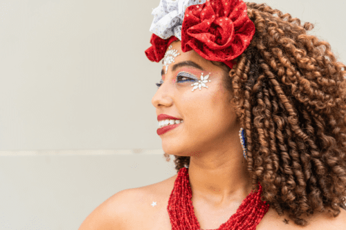 Close-up de uma mulher com maquiagem festiva e adereço de cabeça em um carnaval.