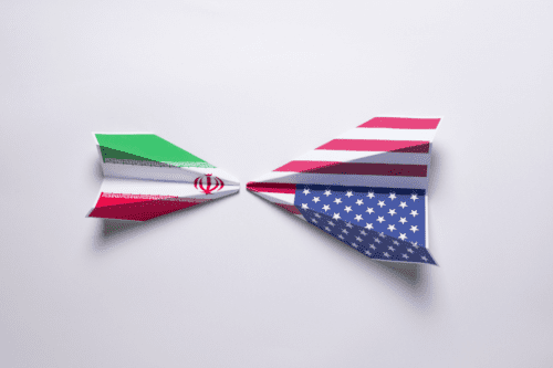 Duas papéis feitos de papel com as bandeiras do Irã e dos Estados Unidos, simbolizando diálogo ou relação entre esses países.