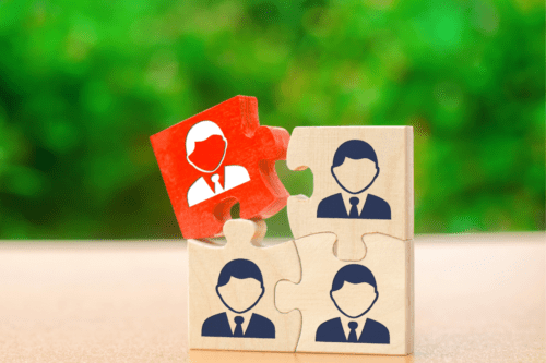 Imagem de um quebra-cabeça com peças ilustrando diferentes pessoas profissionais, simbolizando trabalho em equipe e colaboração empresarial.