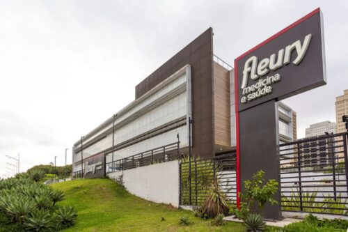 Fachada moderna de uma unidade do Grupo Fleury Medicina e Saúde.