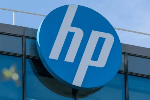 Logotipo circular da HP (Hewlett-Packard) instalado em uma fachada de vidro azul. O círculo é azul com as letras 'hp' brancas e estilizadas, inclinadas para a direita.