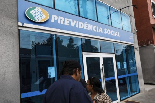 Fotografia em ângulo médio da fachada de uma agência da Previdência Social (INSS).