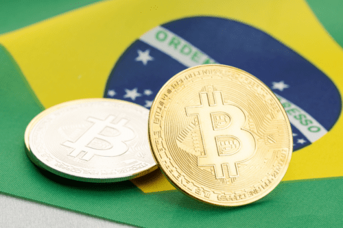 Imagem de duas moedas de bitcoin com fundo da bandeira do Brasil, simbolizando investimento em criptomoedas no Brasil.