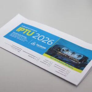 Foto em close de um carnê de pagamento do IPTU 2026 da Prefeitura de Salvador, sobre uma mesa cinza.