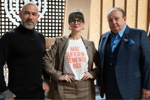 À esquerda: O chef Henrique Fogaça, conhecido por seu estilo marcante, tatuagens e foco em gastronomia contemporânea. Ele veste uma blusa preta de gola alta. Ao centro: A chef Helena Rizzo, que comanda o premiado restaurante Maní. Ela usa óculos de armação escura, um blazer xadrez e uma camiseta branca com a frase em letras vermelhas: "MÃE SUFICIENTEMENTE BOA". À direita: O chef francês Erick Jacquin, um dos mais renomados do país, vestindo um terno azul clássico com colete e um lenço no bolso.