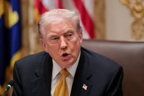 Presidente dos EUA Donald Trump fala durante reunião oficial com bandeiras ao fundo.