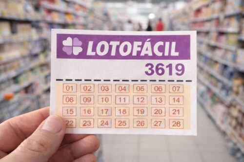 Bilhete da Lotofácil 3619 segurado em supermercado, com prateleiras e carrinho desfocados ao fundo