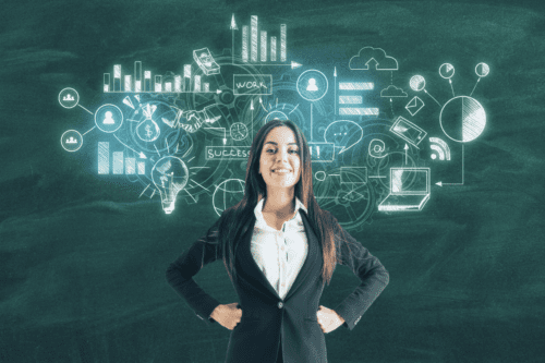 Mulher de negócios sorridente em frente a quadro-negro com desenhos ilustrativos de tecnologia, negócios e sucesso, representando liderança e inovação.