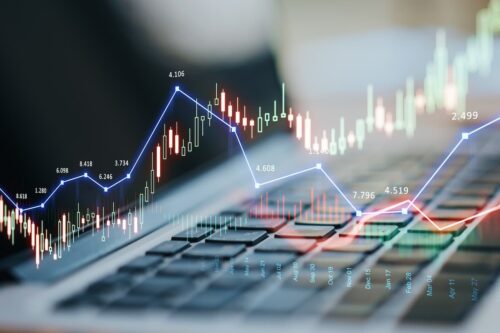 Agenda da semana econômica com gráficos de mercado e indicadores financeiros no computador, destacando dados de inflação no Brasil e nos EUA.