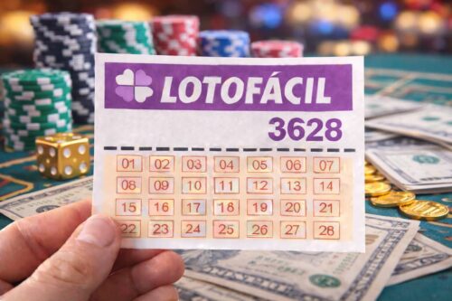 Bilhete da Lotofácil 3628 segurado por uma mão sobre mesa de cassino com fichas, dados, moedas e notas de dólar ao fundo.