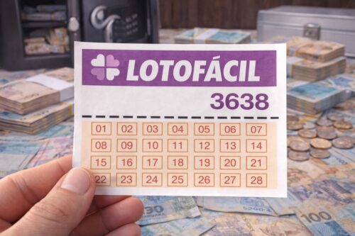 Bilhete da Lotofácil 3638 segurado por mão, com dinheiro, moedas e cofre ao fundo, simbolizando prêmio da loteria.