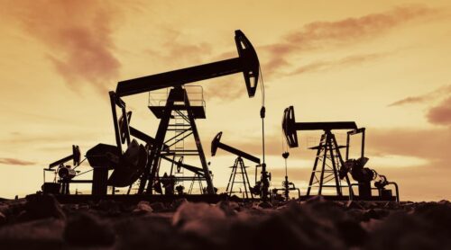Bombas de extração de petróleo em campo ao pôr do sol, ilustrando alta do petróleo com tensões no Oriente Médio.