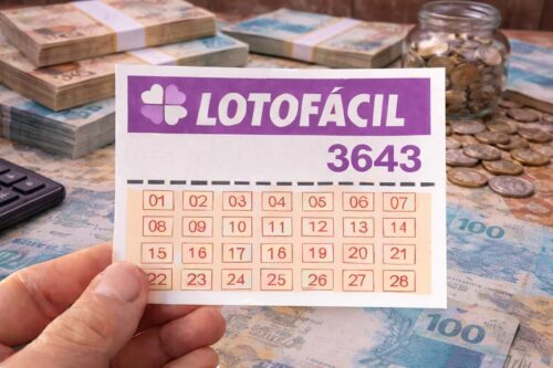 Imagem de uma cartela de bolão Lotofácil 3643, acompanhado de dinheiro, moedas e uma calculadora ao fundo, simbolizando apostas e loterias.