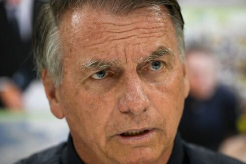 Close do rosto de Jair Bolsonaro, ex-presidente do Brasil, olhando levemente para o lado com expressão séria.