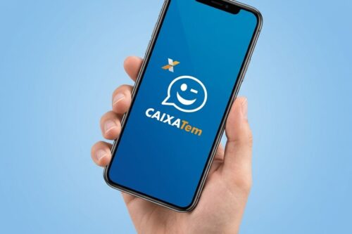 Uma mão segura um smartphone posicionado verticalmente contra um fundo azul claro. A tela do aparelho exibe o logotipo do aplicativo Caixa Tem: um balão de conversa estilizado com um rosto sorridente e piscando, seguido pelo nome "CAIXA Tem" em letras brancas e laranjas.