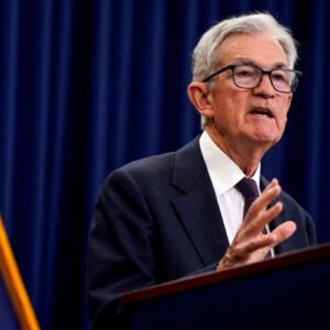 Retrato de Jerome Powell, presidente do Federal Reserve, falando em um púlpito.