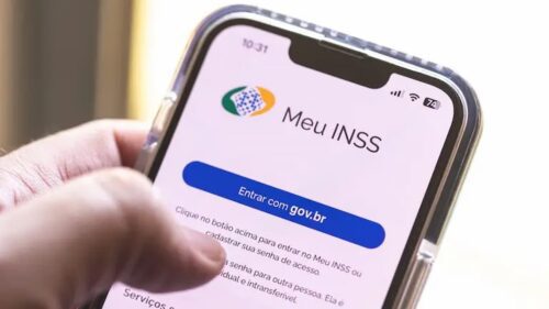 Pessoa acessando o site Meu INSS no smartphone para verificar benefícios e informações previdenciárias.