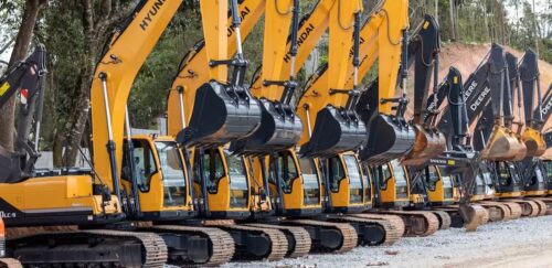 Escavadeiras alinhadas em pátio indicam expansão no setor de máquinas e investimentos em infraestrutura no Brasil.