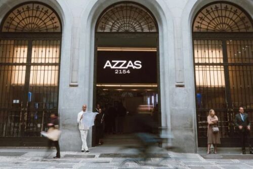 Fachada da Azzas 2154 com pessoas na entrada; empresa tem ações em queda após mudança na liderança.