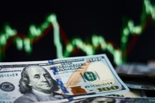 Dólar em destaque com gráfico ao fundo representa dolarização e proteção cambial em cenário econômico instável.