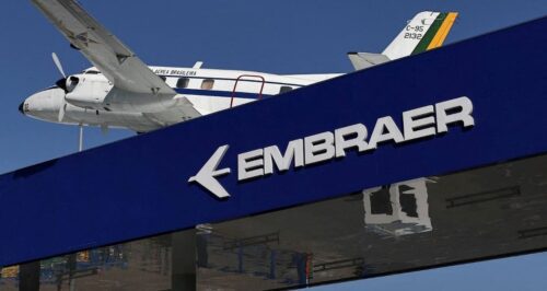 Fachada da Embraer com aeronave ao fundo, ilustrando anúncio de dividendos da companhia na bolsa brasileira.