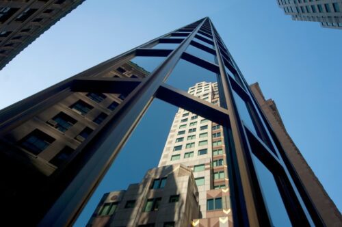 Prédios comerciais vistos de baixo, representando FIIs que pagam dividendos hoje aos investidores.